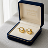 Gold hoop earrings in a 'Embellish Gold Jewelry & Diamond' box on a light surface.