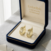 Gold earrings in a 'Embellish Gold Jewelry & Diamond' box on a light background