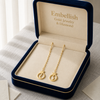 Gold earrings in a 'Embellish Gold Jewelry & Diamond' box on a neutral background
