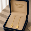 Gold ghost-shaped earrings in a 'Embellish Gold Jewelry & Diamond' box.