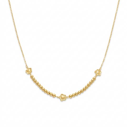 Gold necklace with small floral clasp on a white background