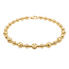 Gold beaded bracelet on a white background