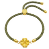 Green braided bracelet with gold accents on a white background
