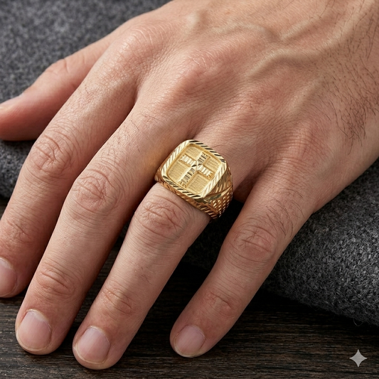 Gold ring on a person's finger with a textured design, set against a dark background.