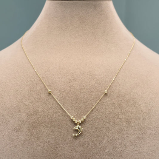 Gold necklace with a pendant on a mannequin bust against a neutral background