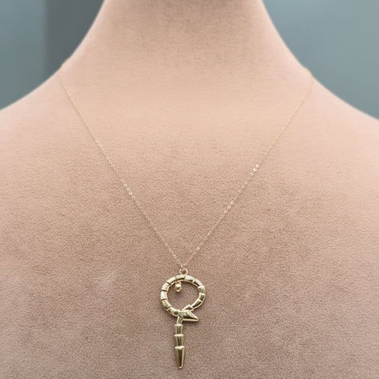 Gold necklace with a key pendant on a mannequin neck, labeled with weight and code.