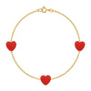 Gold bracelet with red heart-shaped charms on a white background