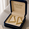 Gold hoop earrings in a 'Embellish Gold Jewelry & Diamond' box on a light surface.