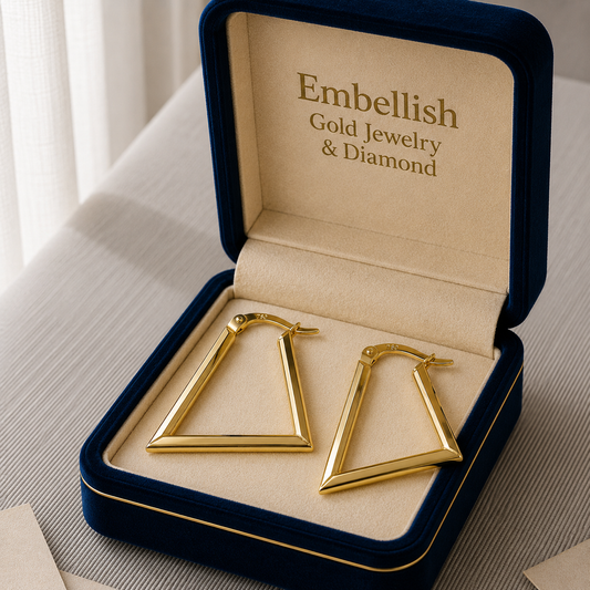 Gold hoop earrings in a 'Embellish Gold Jewelry & Diamond' box on a light surface.