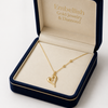 Gold heart necklace in an open jewelry box with 'Embellish Gold Jewelry & Diamond' branding.
