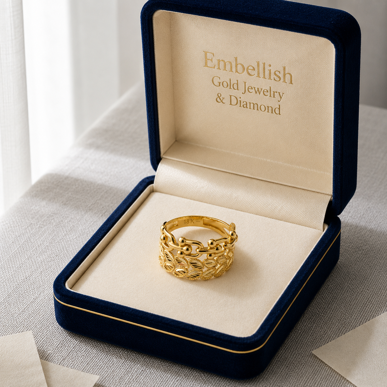 Gold ring in a 'Embellish Gold Jewelry & Diamond' box on a neutral background