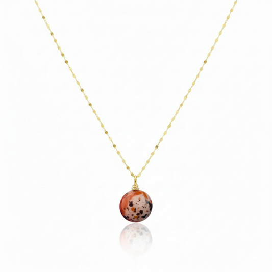 Necklace with a round, multicolored pendant on a thin chain against a white background