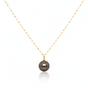 Gold necklace with a dark pearl pendant on a white background