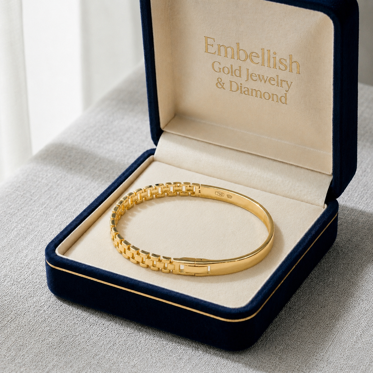 Gold bracelet in an open jewelry box with 'Embellish Gold Jewelry & Diamond' branding.