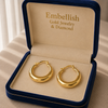 Gold hoop earrings in a 'Embellish Gold Jewelry & Diamond' box.