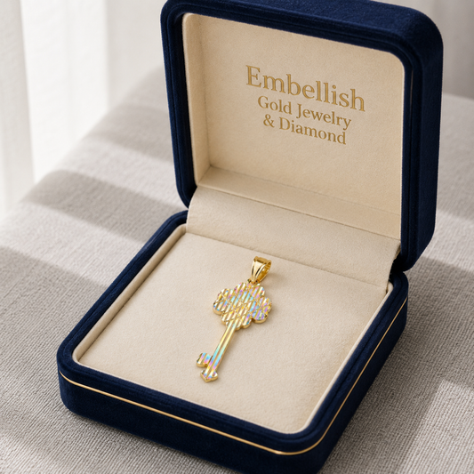 Gold key-shaped pendant in a 'Embellish Gold Jewelry & Diamond' box on a neutral background