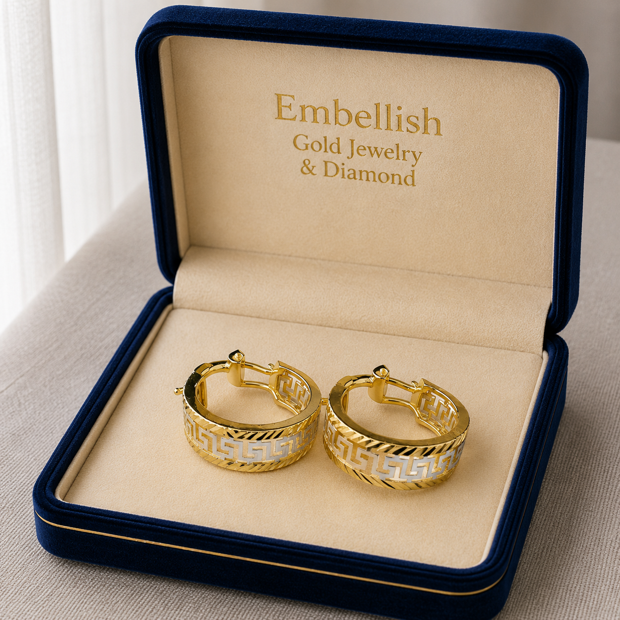 Gold hoop earrings in a 'Embellish Gold Jewelry & Diamond' box.