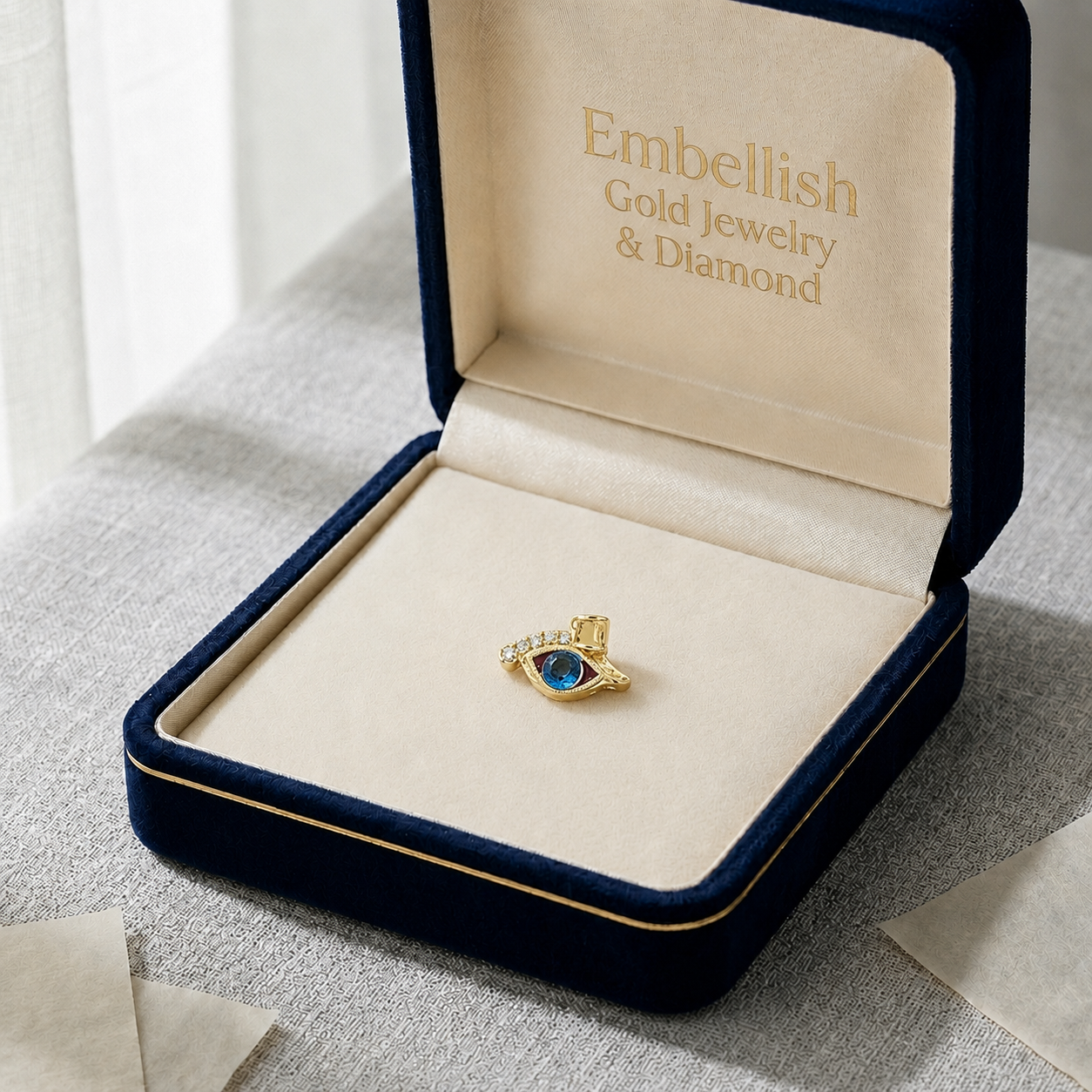 Gold ring with blue gemstone in a 'Embellish Gold Jewelry & Diamond' box on a textured surface.