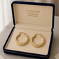 Gold hoop earrings in a 'Embellish Gold Jewelry & Diamond' box.