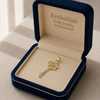 Gold key-shaped pendant in a 'Embellish Gold Jewelry & Diamond' box on a neutral background
