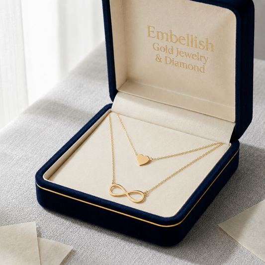 Gold necklace with heart and infinity designs in a 'Embellish Gold Jewelry & Diamond' box.