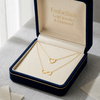 Gold necklace with heart and infinity designs in an 'Embellish' jewelry box.