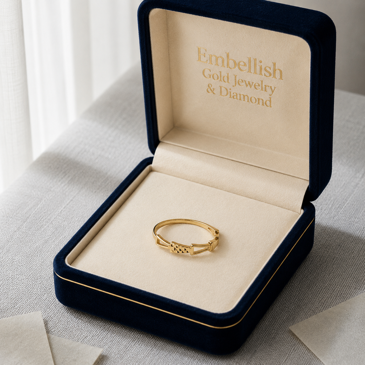 Gold ring in an open jewelry box with 'Embellish Gold Jewelry & Diamond' branding.