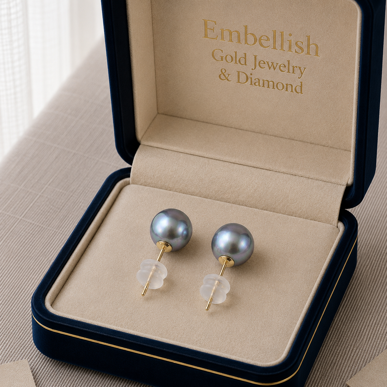 Gray pearl earrings in a 'Embellish Gold Jewelry & Diamond' box.