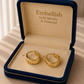 Gold hoop earrings in a 'Embellish Gold Jewelry & Diamond' box.