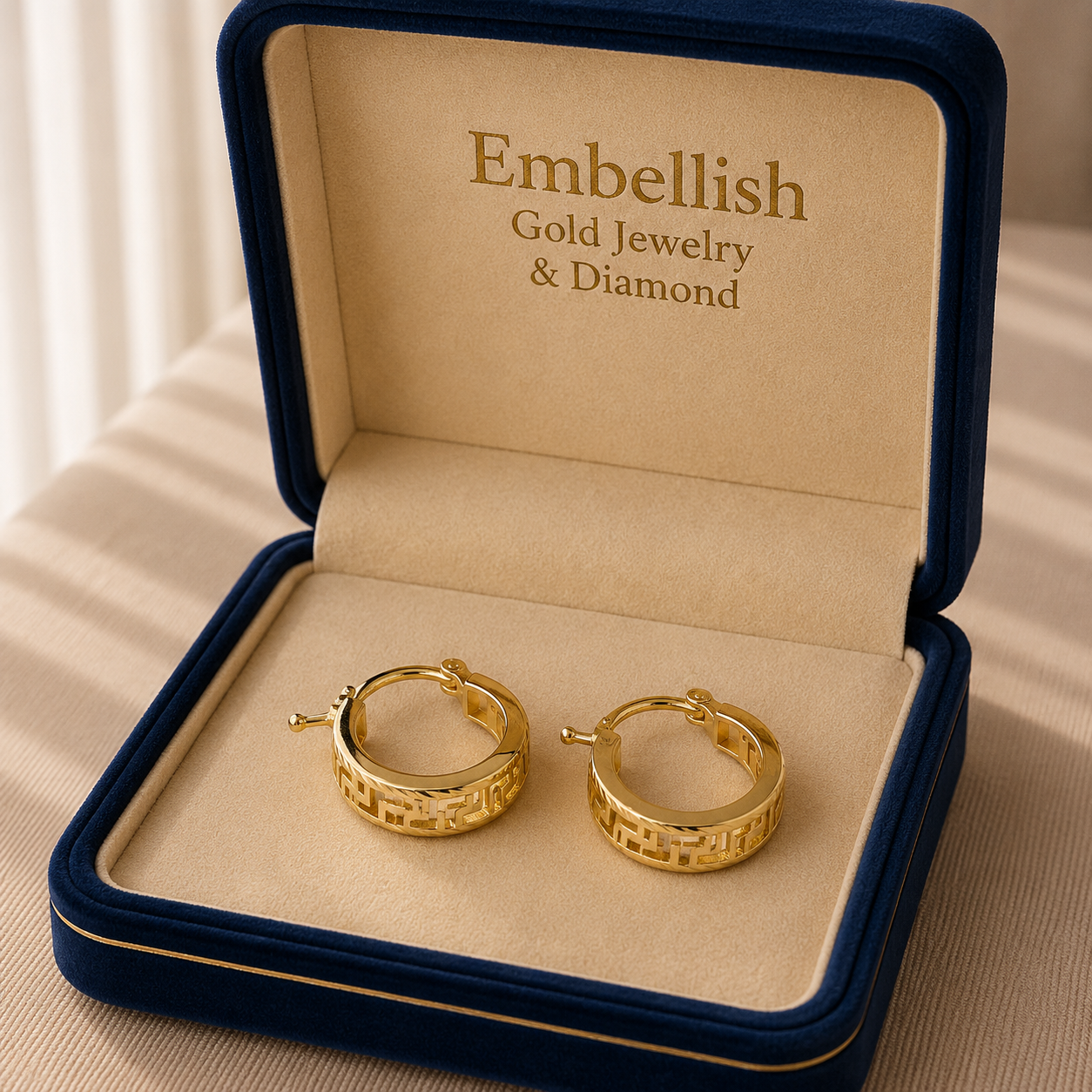 Gold hoop earrings in a 'Embellish Gold Jewelry & Diamond' box.