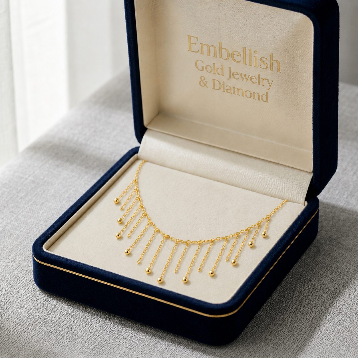 Gold necklace in an open jewelry box with 'Embellish Gold Jewelry & Diamond' branding.