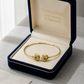 Gold bracelet in a 'Embellish Gold Jewelry & Diamond' box on a light gray surface.