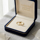Gold hoop earrings in a 'Embellish Gold Jewelry & Diamond' box on a light gray surface.
