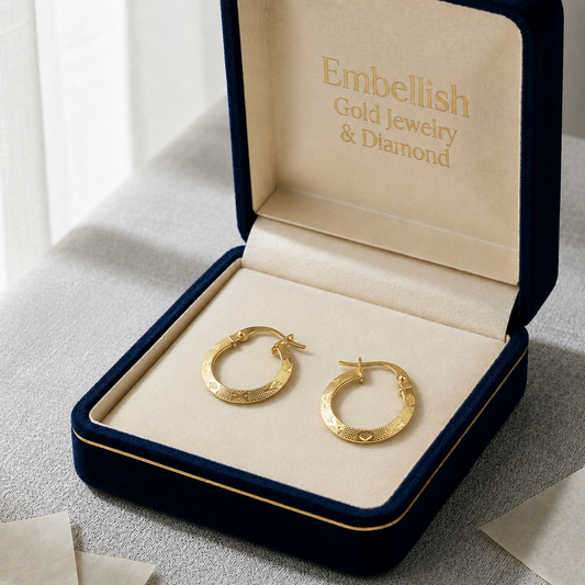 Gold hoop earrings in a 'Embellish Gold Jewelry & Diamond' box on a light surface.