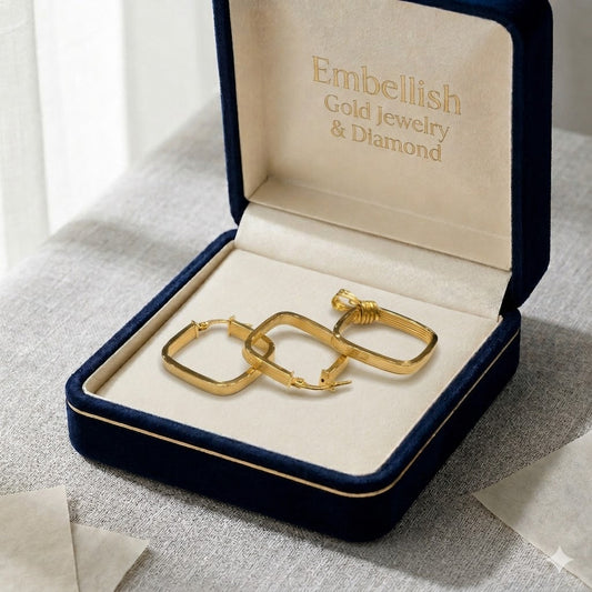 Gold hoop earrings in a 'Embellish Gold Jewelry & Diamond' box on a textured surface.