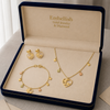 Gold jewelry set including necklace, bracelet, and earrings in an 'Embellish' box.