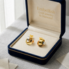 Gold earrings in a 'Embellish Gold Jewelry & Diamond' box on a light background