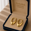 Gold hoop earrings in a 'Embellish Gold Jewelry & Diamond' box.