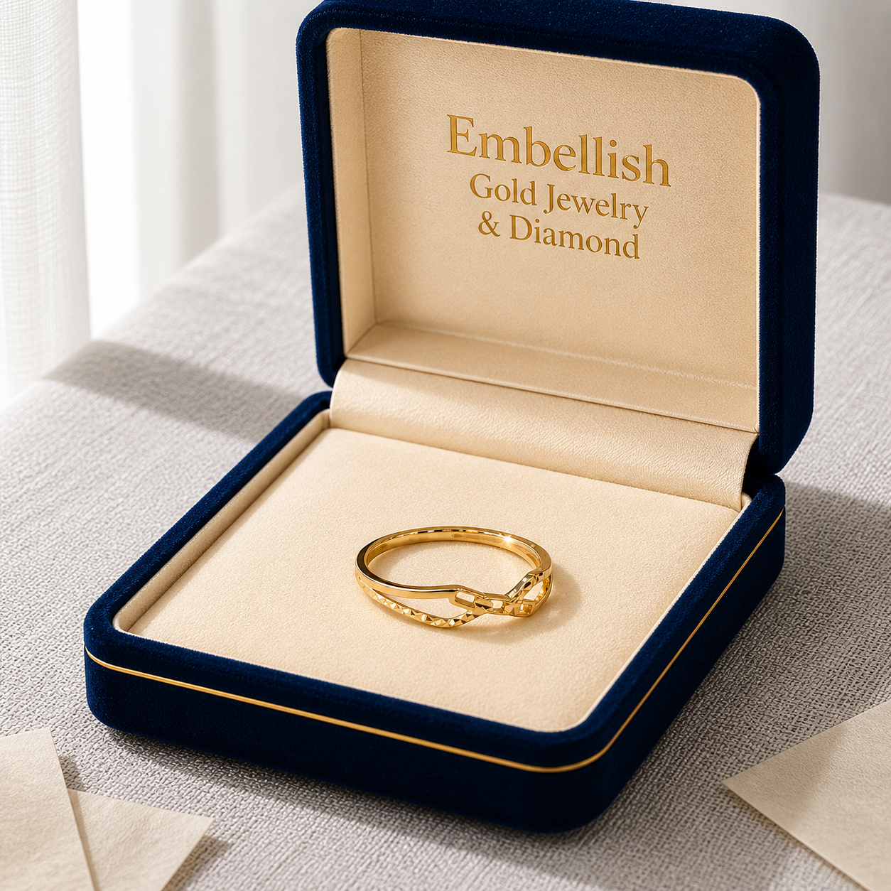 Gold ring in a 'Embellish Gold Jewelry & Diamond' box on a textured surface.
