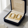 Gold hoop earrings in a 'Embellish Gold Jewelry & Diamond' box on a light surface.