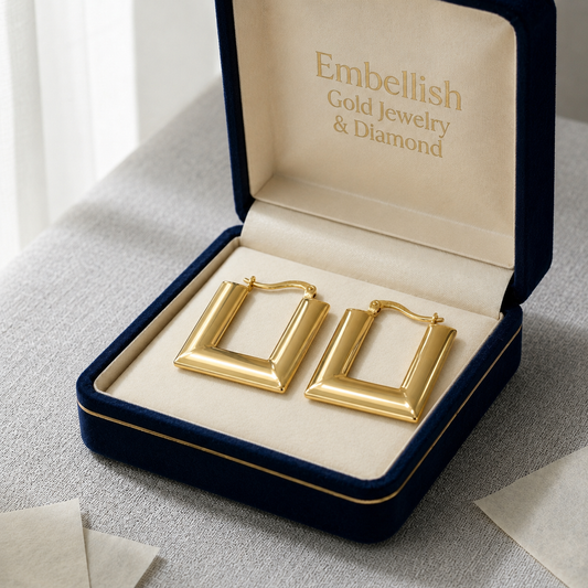 Gold hoop earrings in a 'Embellish Gold Jewelry & Diamond' box on a light surface.