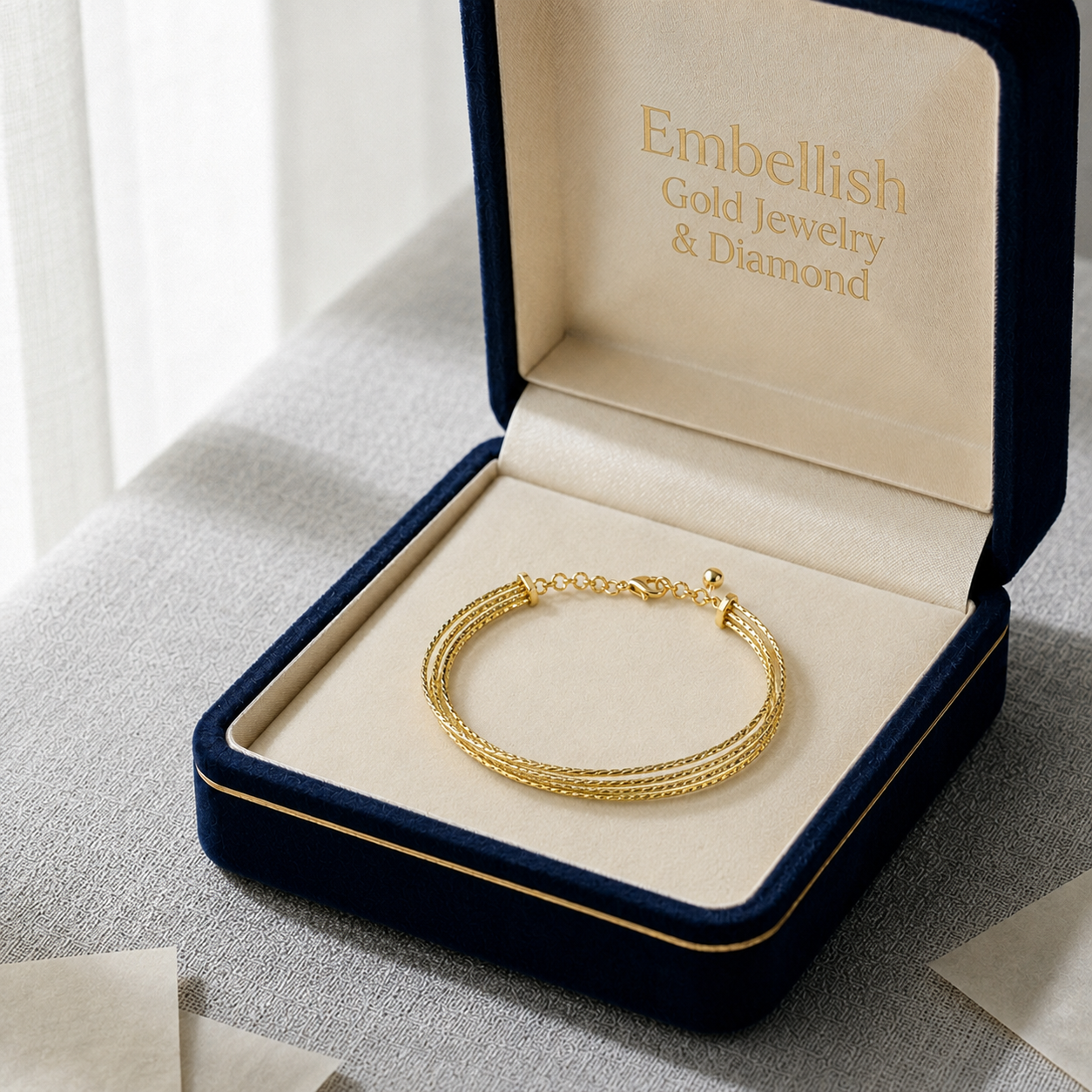 Gold bracelet in an open jewelry box with 'Embellish Gold Jewelry & Diamond' branding.