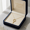 Gold necklace with a key pendant in an open jewelry box labeled 'Embellish Gold Jewelry & Diamond'.