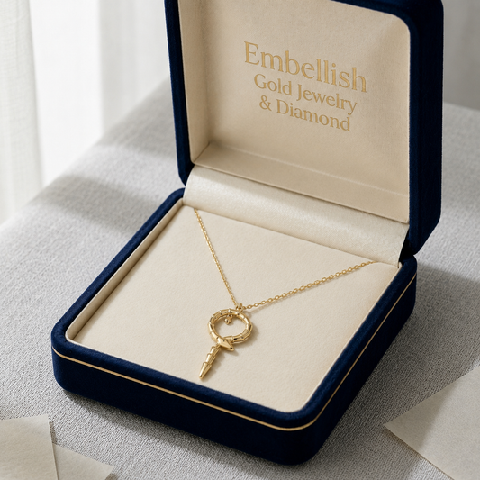 Gold necklace with a key pendant in an open jewelry box labeled 'Embellish Gold Jewelry & Diamond'.