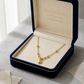 Gold necklace with a heart pendant in an open jewelry box labeled 'Embellish Gold Jewelry & Diamond'.