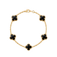 Gold bracelet with black clover-shaped charms on a white background