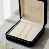 Gold cat-shaped earrings in a 'Embellish' jewelry box on a light surface.