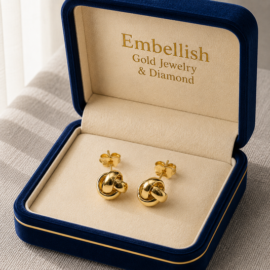 Gold earrings in a 'Embellish Gold Jewelry & Diamond' box on a neutral background