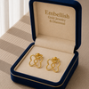 Gold earrings in a 'Embellish Gold Jewelry & Diamond' box on a striped fabric background