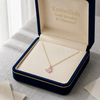 Gold necklace with a pink butterfly pendant in an open jewelry box labeled 'Embellish Gold Jewelry & Diamond'.